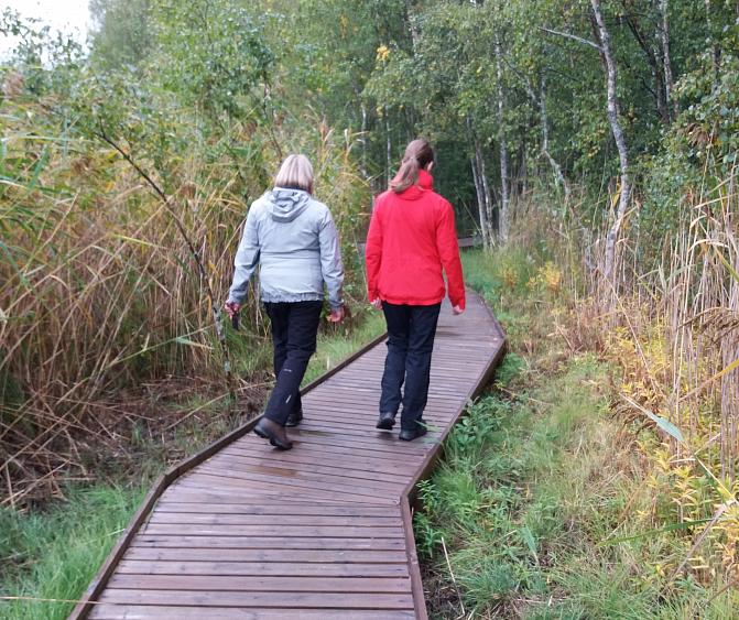 Kaksi henkilöä kävelee esteettömällä reitillä.