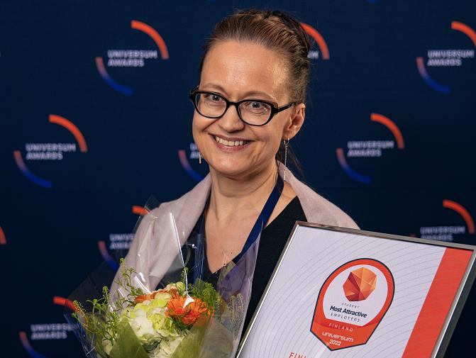 Tuija Heikkinen vastaanotti Universum-tunnustuksen luonnontieteiden opiskelijoiden halutuimmasta työpaikasta. Heikkinen hymyilee kameralle kädessään kukkakimppu ja todistus Luken ensimmäisestä sijasta selvityksessä.