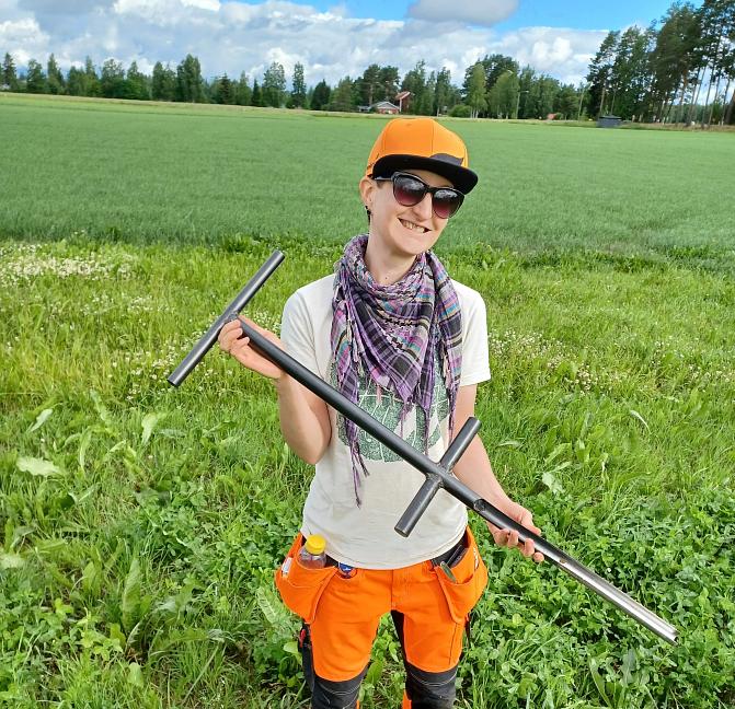 Anni Palvi seisomassa vehreällä nurmipellolla.