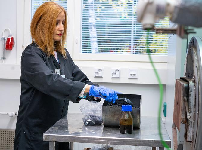 Tutkija valmistelee näytettä pyrolyysiuunille.