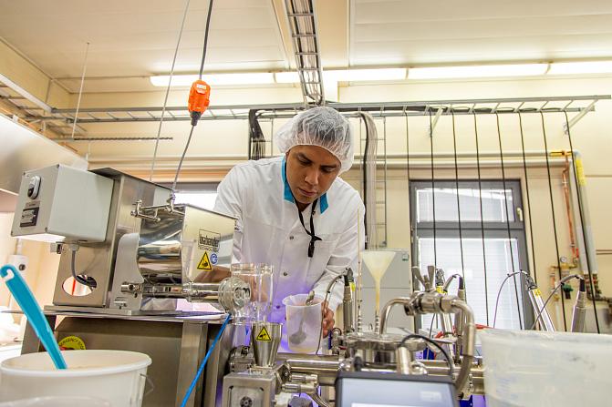 Tutkija Luken ekstruusiokeskuksessa töissä ekstruuderin äärellä.