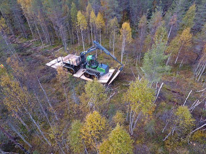 Metsäkone metsikössä, alla CLT-levyjä uppoamisen estämiseksi