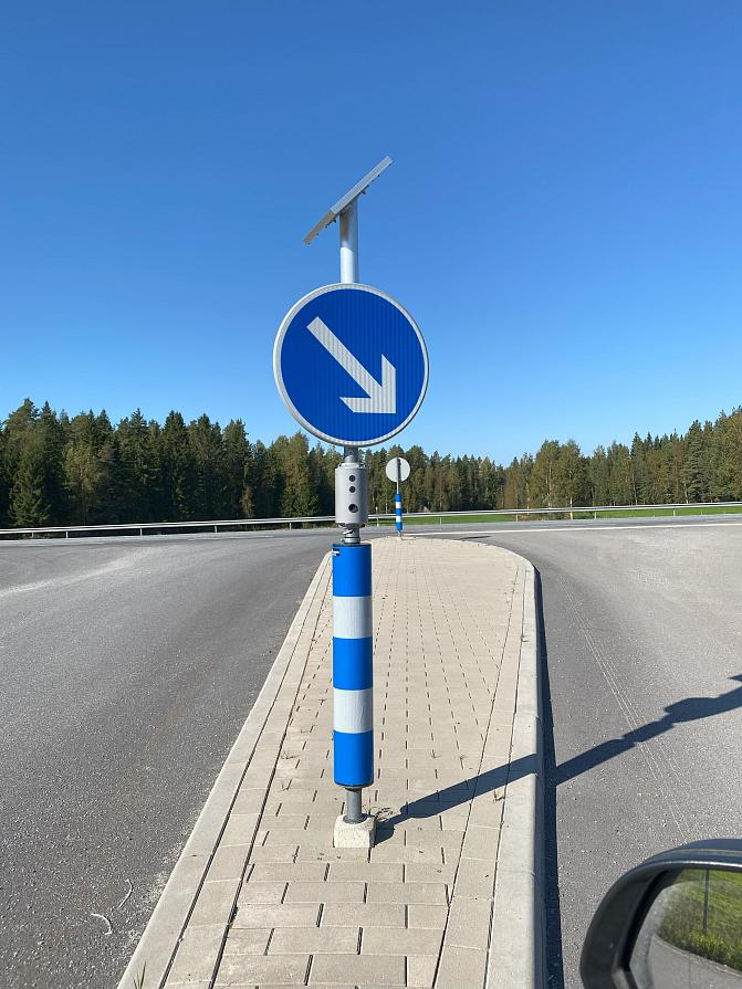 Kuvassa liikennemerkkipylväs, johon on kiinnitetty ääntä tuottava laite.