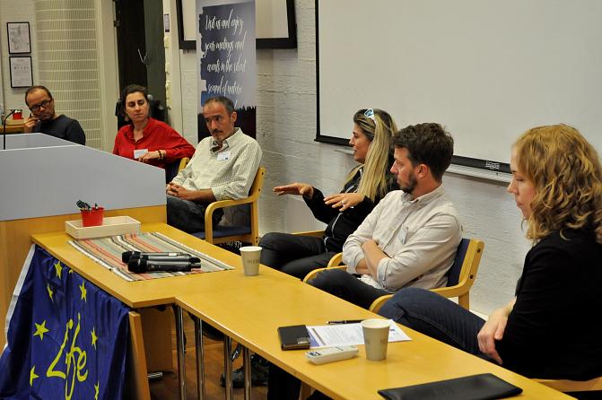Six people are discussing with each other in a panel discussion at a seminar.