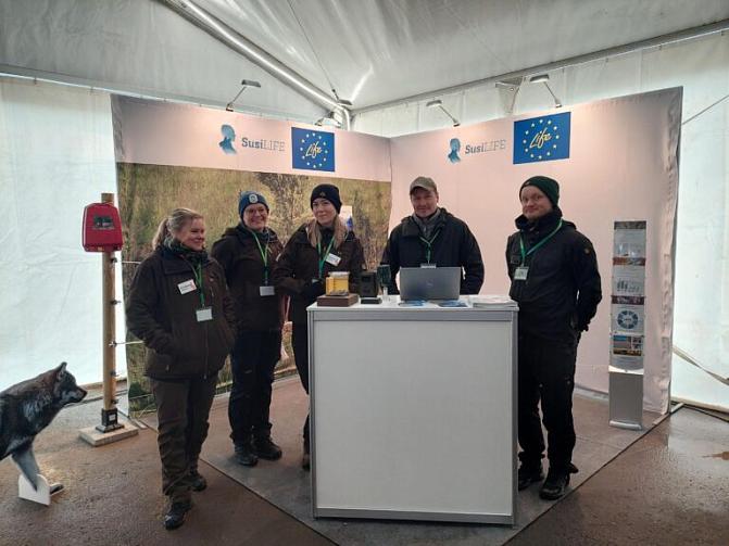 Människor står i rad vid en mässmonter.