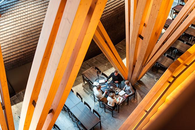 kokous puupylväiden keskellä puurakennuksessa