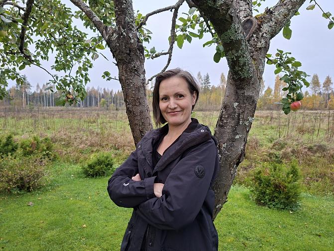 Kuvassa näkyy Kristiina puolilähikuvassa. Hänen takanaan on kaksi puuta ja vehreää maisemaa,