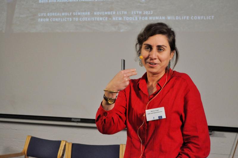 A woman giving a presentation in front of a projection screen.