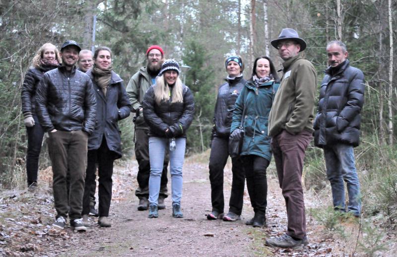 A group of happy people on a forest trail among the trees.