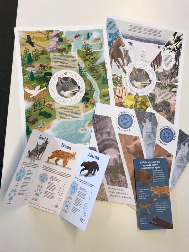 A pile of brochures, posters, and teacher's guides on a table.