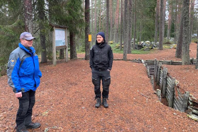  Två personer står i skogen.