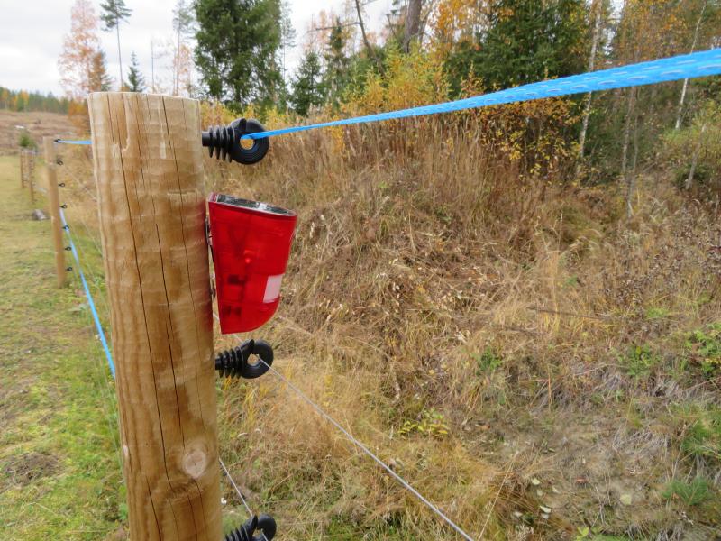 Ääni- ja valokarkotin kiinnitettynä petoaidan tolppaan.