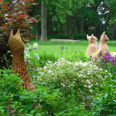 Kolme suurta kissapatsasta puutarhassa.