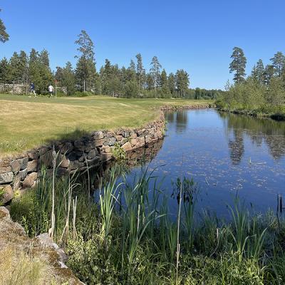 A body of water next to a golf course