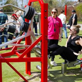 Ihmisiä seisomassa ja liikkumassa ulkoliikuntapaikan äärellä